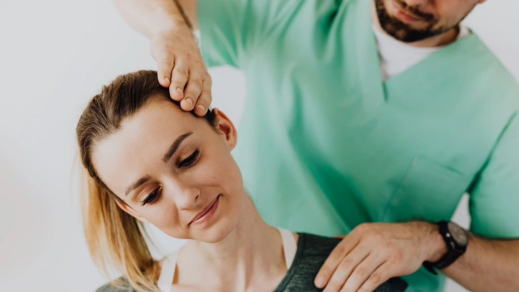 Kvinna får professionell nackbehandling av terapeut för återhämtning