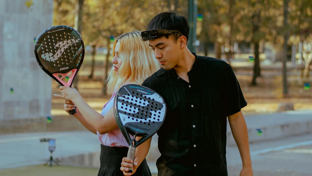 Två personer på padelbana med racketar redo att spela