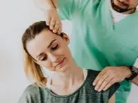 Kvinna får professionell nackbehandling av terapeut för återhämtning