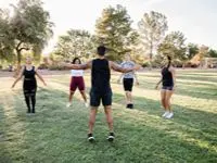 Gruppträning utomhus med deltagare som tränar tillsammans på gräsplan