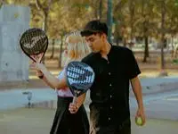 Två personer på padelbana med racketar redo att spela